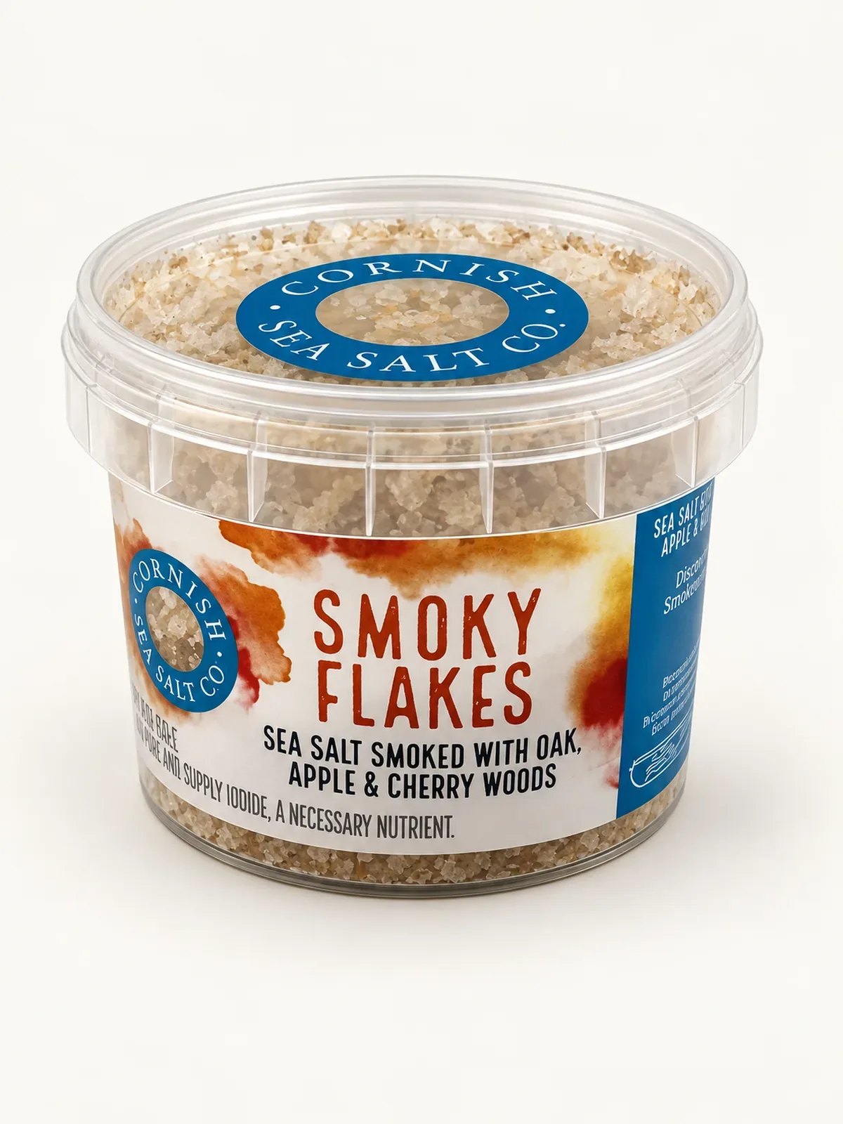 Front of a clear tub of Cornish Sea Salt Co. Smoky Flakes with its orange and blue label