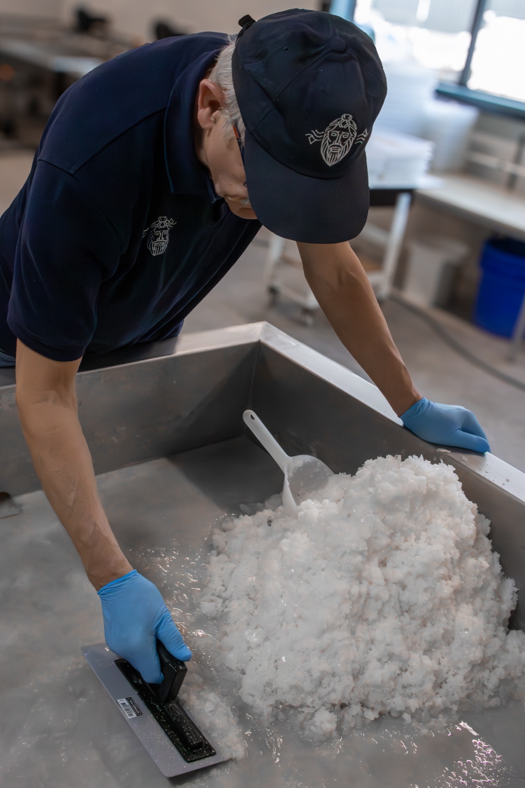 A Zeeuwsche Zoute saltmaker working with wet salt crystals in a metal tray